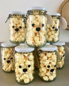 there are many jars with popcorn in them that have faces on the lids and ears