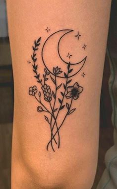 a black and white tattoo with flowers on the thigh