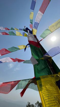 many colorful flags are flying in the air