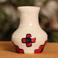 a white and red vase sitting on top of a table