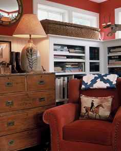 a red chair sitting in front of a wooden dresser