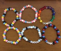 four bracelets with different colored beads on a table