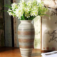 a vase filled with white flowers on top of a wooden table