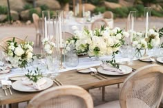 the table is set with white flowers and candles