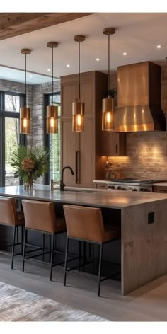 a large kitchen with an island in the middle and lots of lights hanging above it