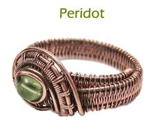 a wire wrapped ring with a green bead on it's center and the words peridot written below