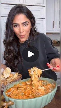 a woman is holding a spoon full of food