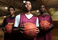 three young men holding basketballs in a gym