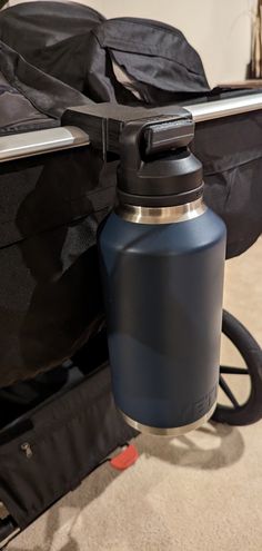 a blue water bottle sitting next to a black bag