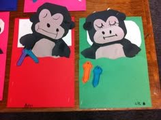 paper cut out of monkeys sitting on top of a wooden table next to scissors and glue