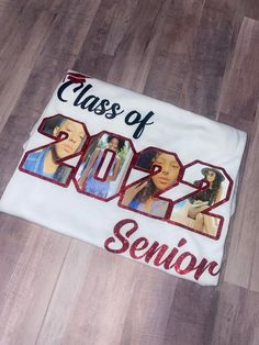 a class of 2012 t - shirt on the floor with some pictures printed on it