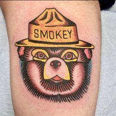 a bear wearing a hat with smokey written on it's forehead and eyes