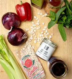 ingredients to make an entree laid out on a cutting board with peppers, onions, sunflowers and beans