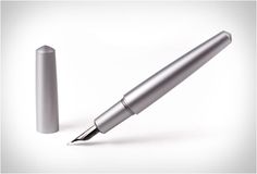 a silver pen sitting on top of a white surface