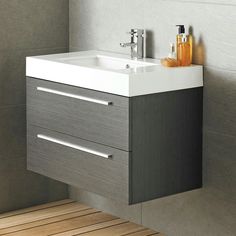 a white sink sitting under a mirror next to a wall mounted faucet in a bathroom