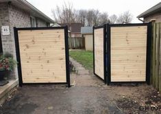 two wooden gates open in front of a house