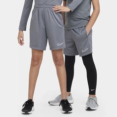 two people standing next to each other wearing nike shorts and shirts with their hands on their hips