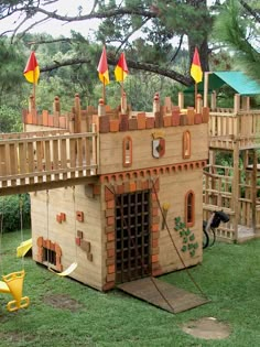 a play house made out of wood and bricks with flags on it's roof