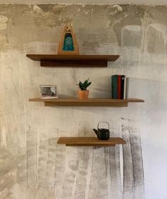 two wooden shelves on the wall with books and other items in front of them,