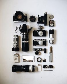 many different types of cameras are arranged on a white surface