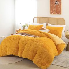 a bed with yellow comforters and pillows in a room