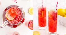 two glasses filled with red liquid next to lemons and strawberries