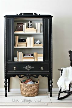 a black bookcase sitting next to a rocking chair