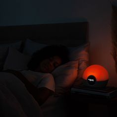 a person laying in bed next to a night light