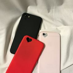 two iphone cases sitting next to each other on top of a white sheet covered bed