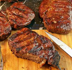 the steaks are ready to be grilled and served on the grill with a knife