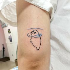 a person with a small tattoo on their arm that has a seal in the water