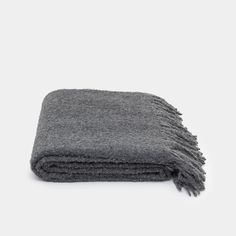 a gray blanket folded on top of a white table