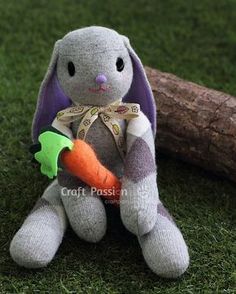 a stuffed bunny holding a carrot on the grass