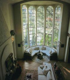 a living room filled with furniture and large windows