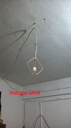 an overhead light fixture with wires attached to the ceiling in a room that is white