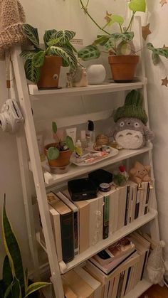 a book shelf filled with books and plants