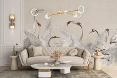 a living room with two couches and three birds on the wall