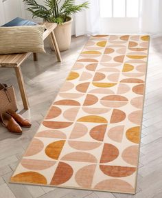 an orange and beige rug with circles on it in a living room next to a chair