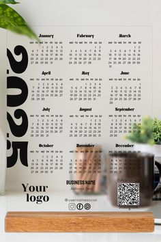 a desk with a calendar on it next to a potted plant