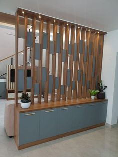 a room divider made out of wooden slats with planters on the top