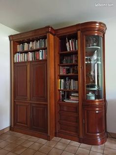 an empty room with bookshelves, cabinets and tile flooring on the walls