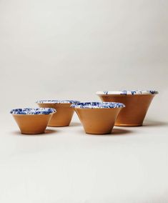 three bowls with blue and white designs are shown in front of a plain gray background