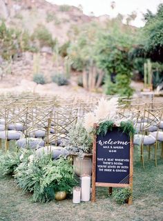 an outdoor ceremony set up with chairs and greenery