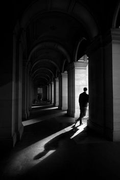 a man is standing in an empty hallway