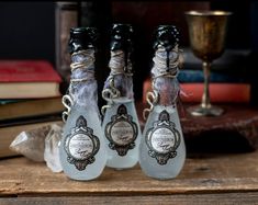 three glass bottles sitting on top of a wooden table