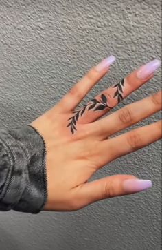 a woman's hand with some tattoos on it