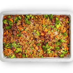 a casserole dish filled with broccoli, carrots and rice