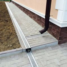 an image of a drain in the ground that is going to be installed on the side of a building