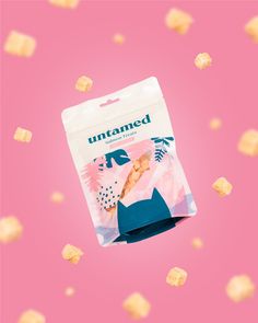 a bag of untamted crackers sitting on top of a pink background with gold flecks