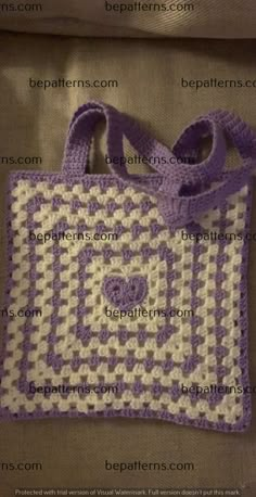 a crocheted bag with a heart on the front and bottom is shown in white and purple